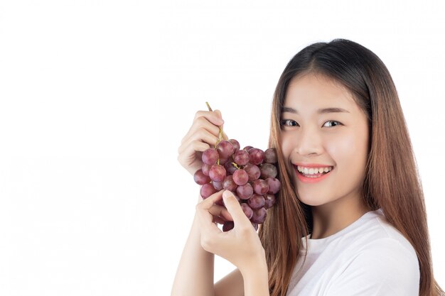 Beautiful woman with a happy smile holding a hand grape, isolated on white background.