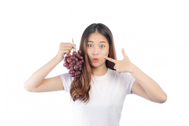 Beautiful woman with a happy smile holding a hand grape, isolated on white background.