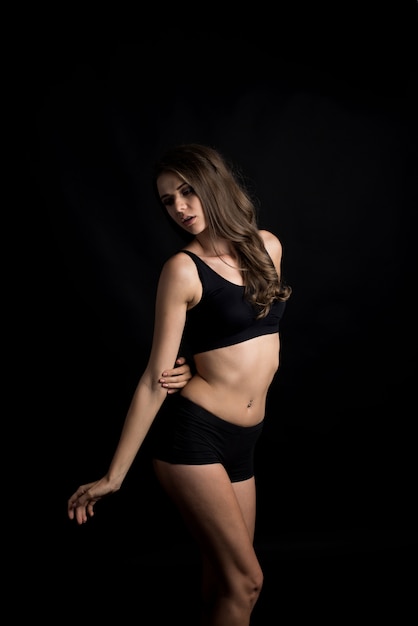 Beautiful woman with healthy body on black background