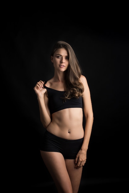 Beautiful woman with healthy body on black background