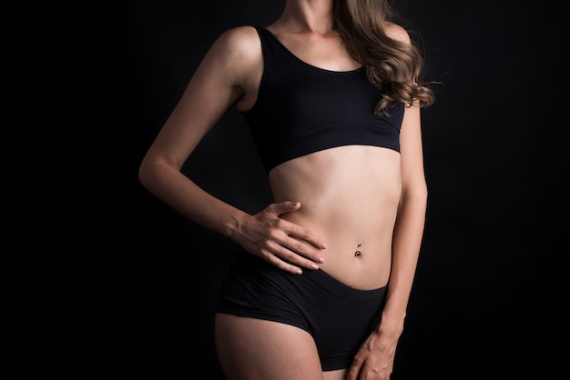 Beautiful woman with healthy body on black background