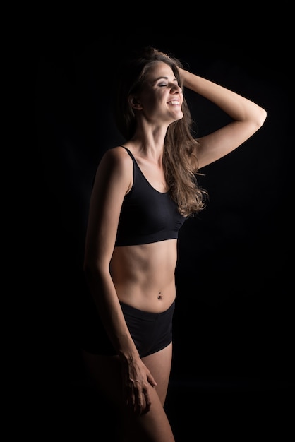 Beautiful woman with healthy body on black background