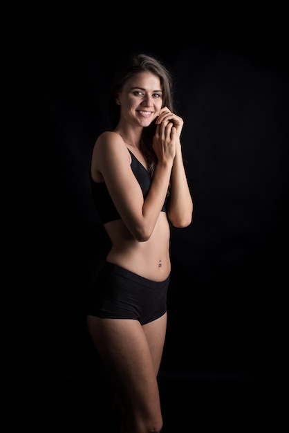 Beautiful woman with healthy body on black background