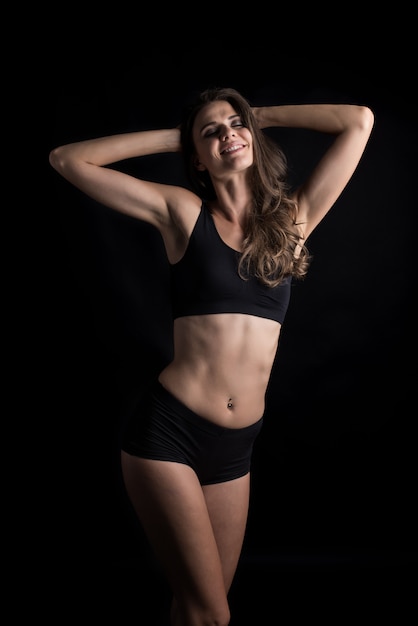 Beautiful woman with healthy body on black background