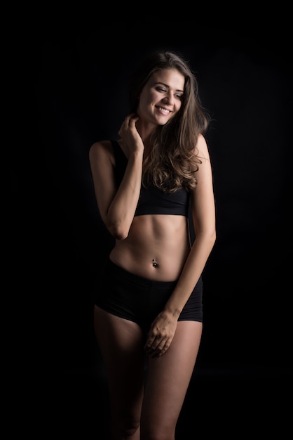 Beautiful woman with healthy body on black background