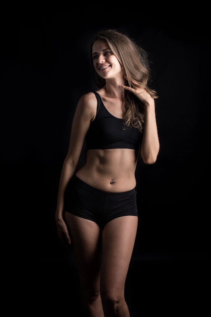 Beautiful woman with healthy body on black background