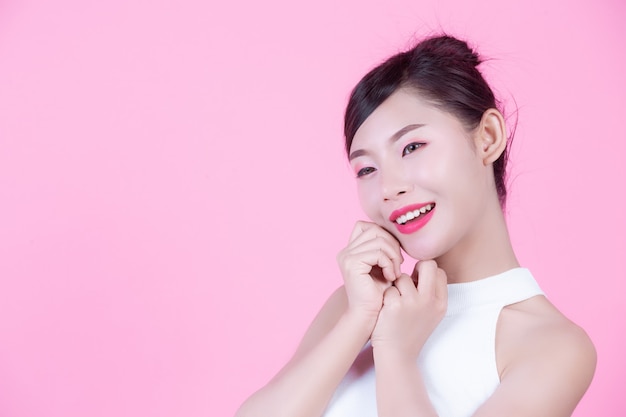 Beautiful woman with healthy skin and beauty on a pink background.