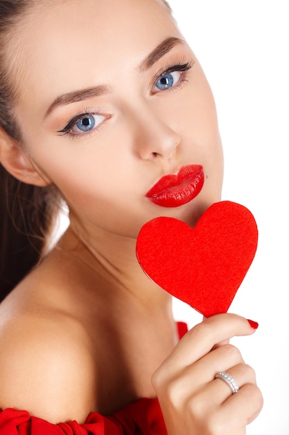 Free photo beautiful woman with a heart indoor isolated