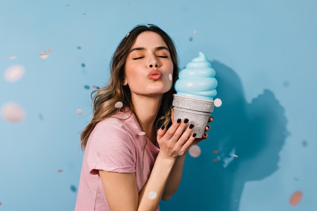 Beautiful woman with ice cream sending air kiss