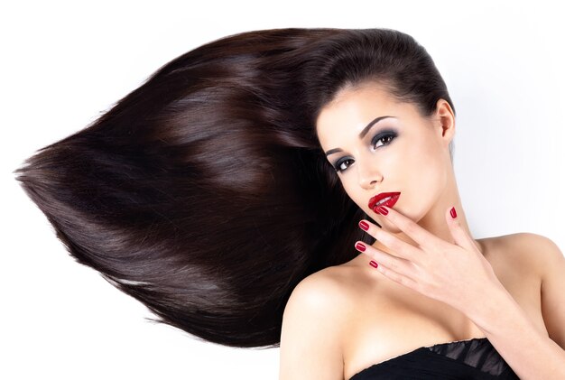 Beautiful woman with long brown straight hairs and elegance red nails