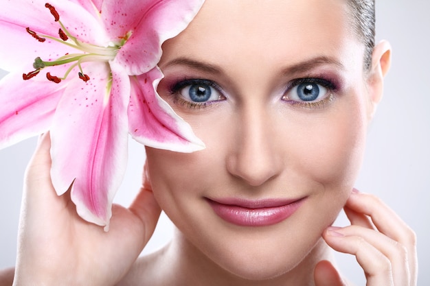 Beautiful woman with pink lily flower