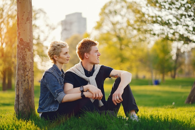 beautiful woman with short light hair, dressed in a blue jeans jacket sitting with her boyfriend