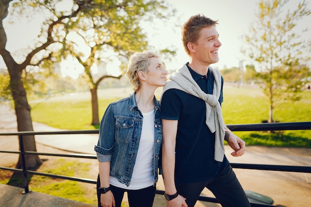 beautiful woman with short light hair, dressed in a blue jeans jacket walks with her boyfriend