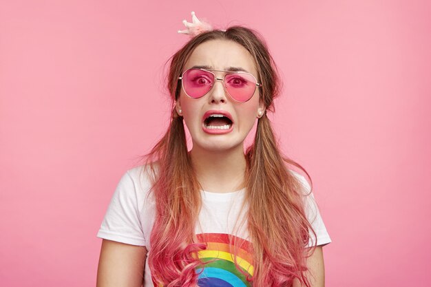 トレンディなピンクのサングラスを持つ美しい女性