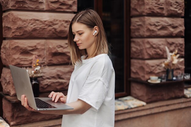 Beautiful woman working on laptop at the city