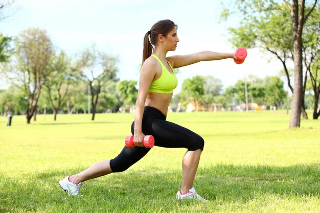 Beautiful woman working out with dumbbells 