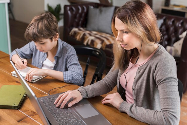 Beautiful woman working next to young boy