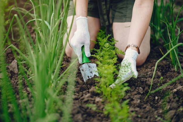 Beautiful woman works in a garden near the house