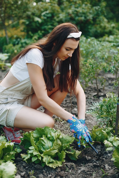 Beautiful woman works in a garden 