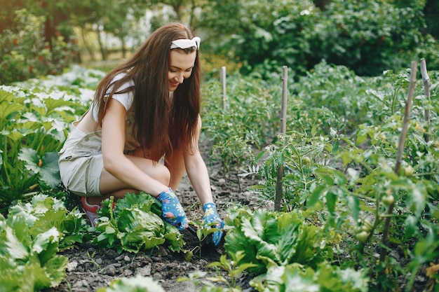 Beautiful woman works in a garden 