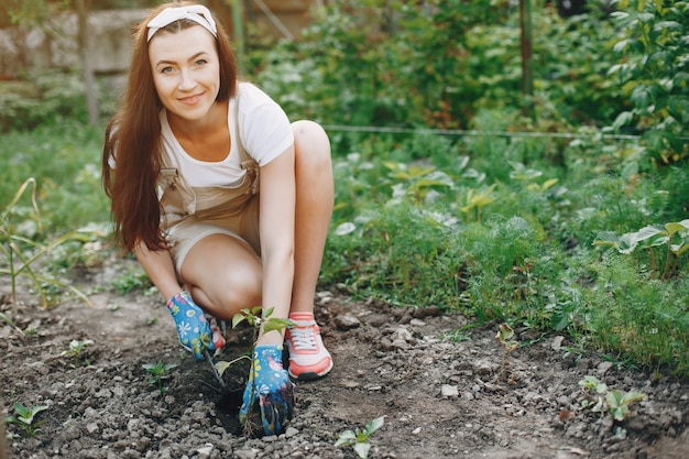 La bella donna lavora in un giardino