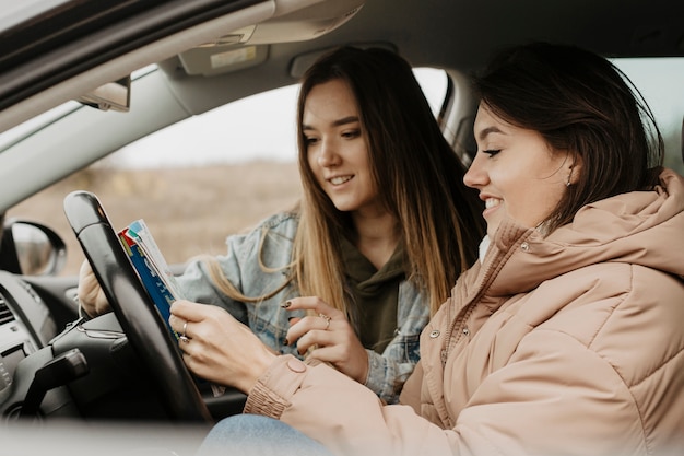 Beautiful women checking travel map side view