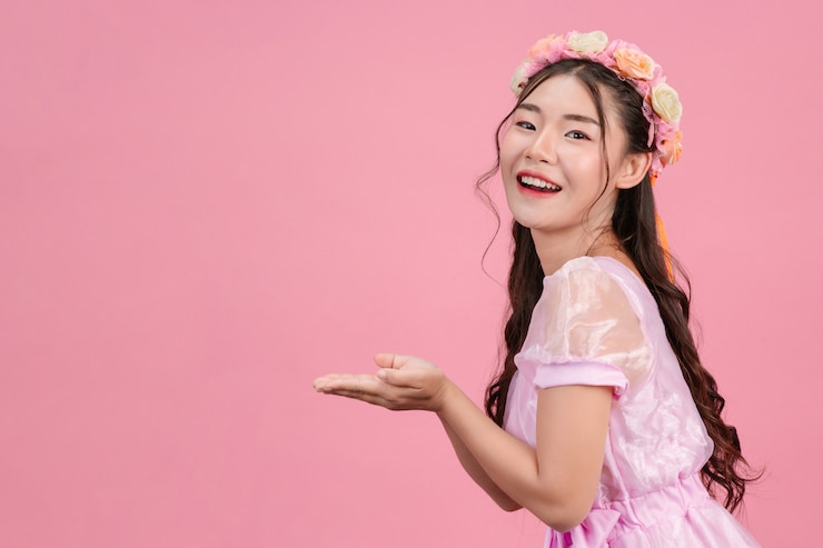 免費 Photo 穿著漂亮的粉紅色公主禮服的漂亮女人站在粉紅色上.