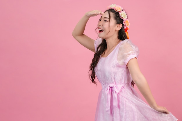 Beautiful women dressed in beautiful pink princess dresses are standing on a pink .