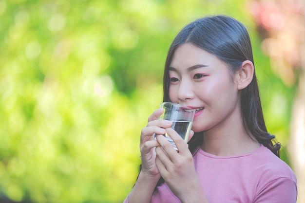 Beautiful women drink clean water from a glass of water