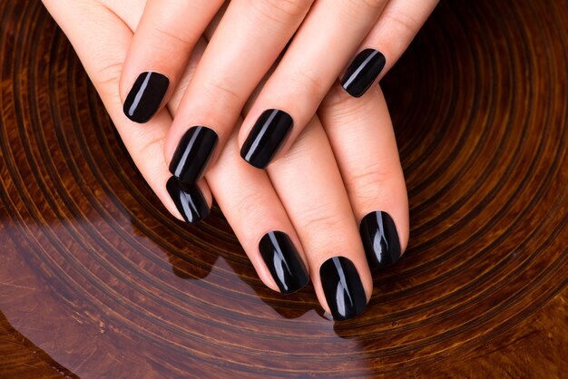 Foto gratuita mani di belle donne con il manicure nero dopo procedure spa - concetto di trattamento spa