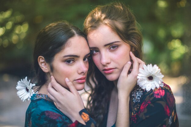 Beautiful women holding flowers and hugging