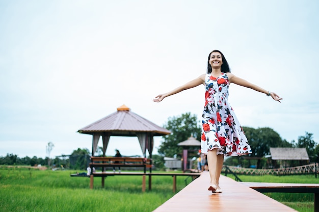 Beautiful women walk happily on the wooden bridge