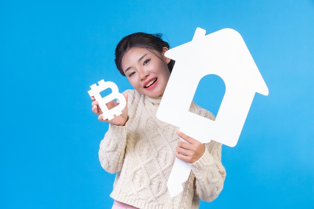 Beautiful women wear new long sleeved white shirts with the house symbol and baht on a blue . House trading .