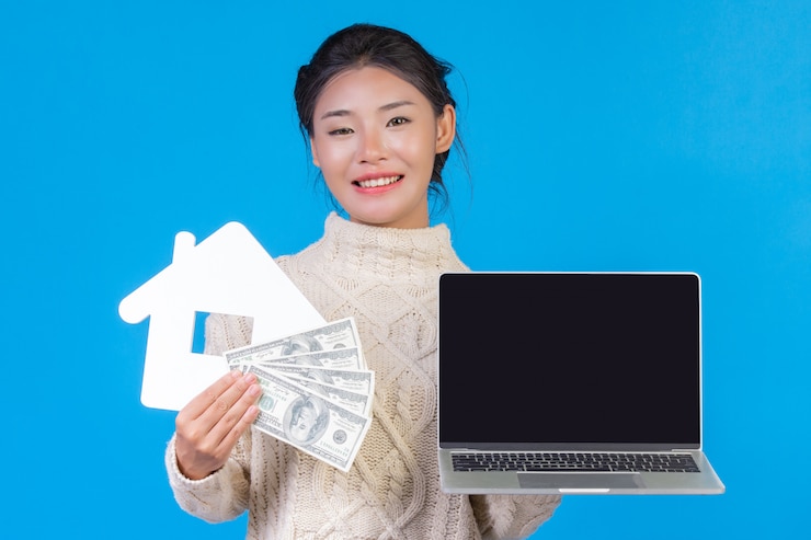 無料Photo ノートを保持している新しい長袖の白いカーペットを着ている美しい女性。青の家とドル紙幣のシンボル。貿易 。