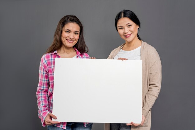 Beautiful womens holding blank paper sheet