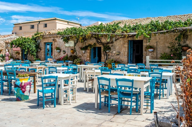 Beautiful wooden chairs and table in front of a beautiful old house under the sky