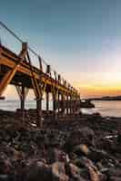 Free photo beautiful wooden pier at the coast of the sea with a beautiful sunset