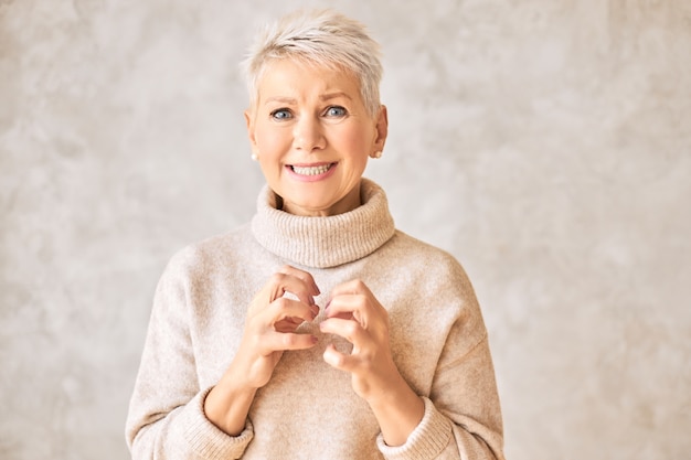 Free photo beautiful worried retired woman wearing cozy sweater and short hairdo