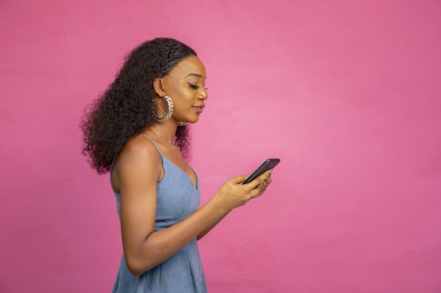 Beautiful young African woman using her mobile phone