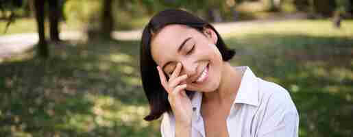 Free photo beautiful young asian girl smiling laughing and walking along park enjoying summer sunny day