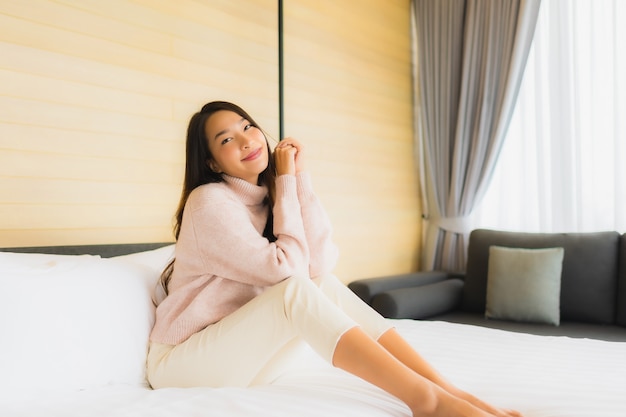 красивая молодая азиатская женщина счастлива, отдыхая на кровати