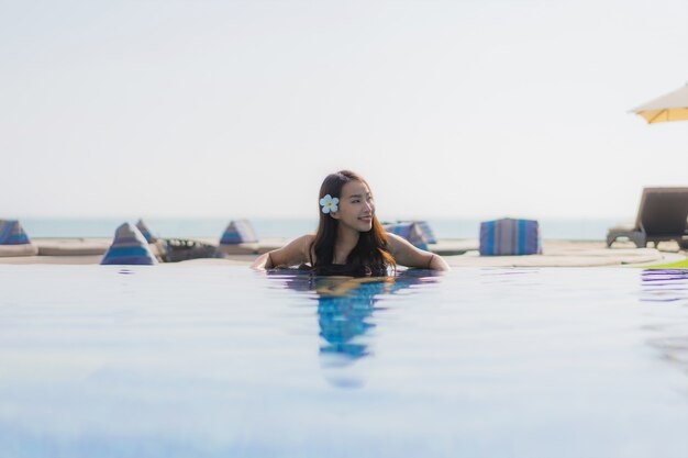 아름 다운 젊은 아시아 여자 행복 한 미소와 수영장에서 휴식