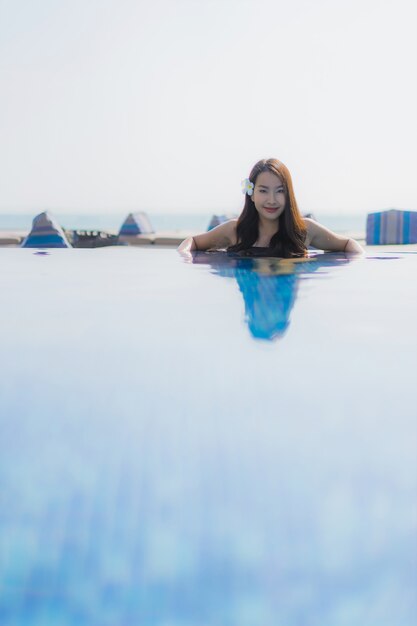 Beautiful young asian woman happy smile and relax in swimming pool