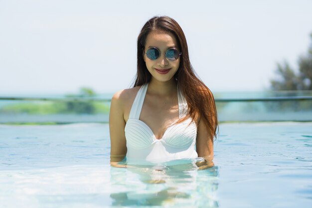 아름 다운 젊은 아시아 여자 행복과 휴식 여행 및 휴가 수영장에서 미소