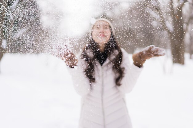 雪の冬の季節に旅行のために幸せな笑みを浮かべて美しい若いアジア女性
