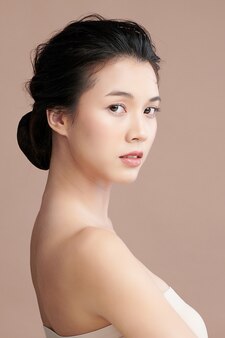 ベージュ​の​背景​、​フェイス​ケア​、​フェイシャルトリートメント​、​美容​、​美容​と​スパ​、​アジア​の​女性​の​肖像画​に​きれいな​新鮮な​肌​を​持つ​美しい​若い​アジア​の​女性​。