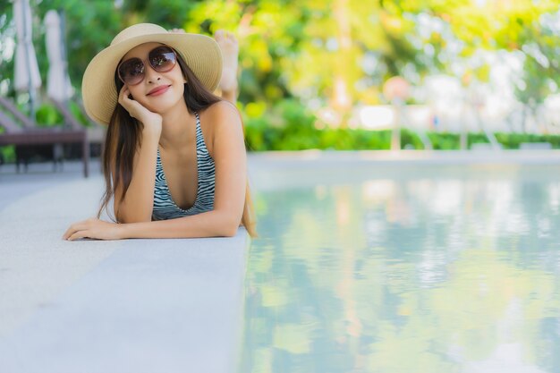 Beautiful young asian women happy smile relax around outdoor swimming pool in hotel resort