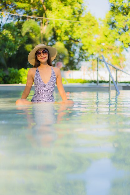 Beautiful young asian women happy smile relax around outdoor swimming pool in hotel resort