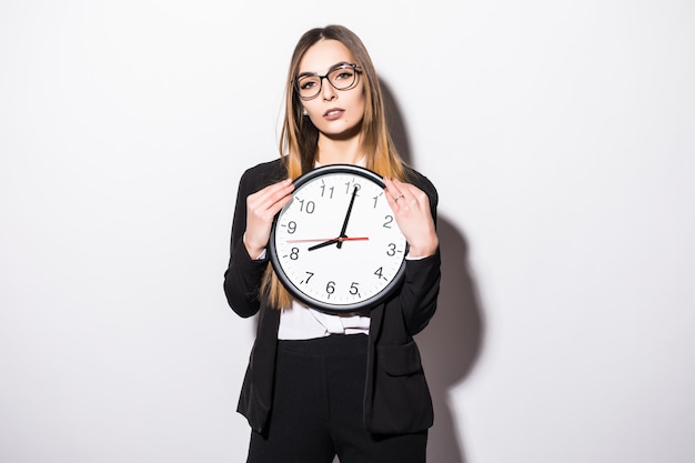 Beautiful young business woman holding in hands clock on white