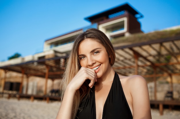 Beautiful young cheerful girl rests at morning beach